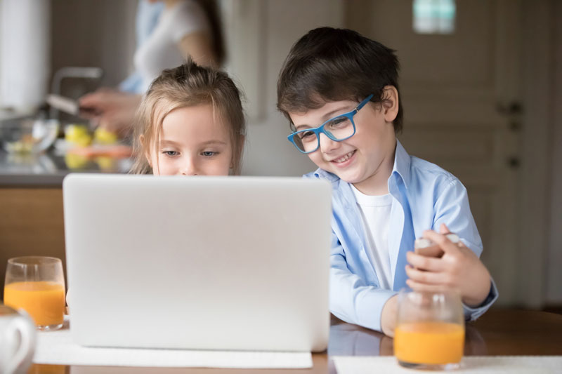 Two kids looking at a laptop screen