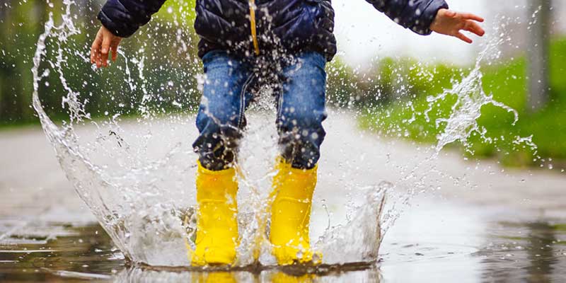 Rainy day games, Kid jumping in puddle of water