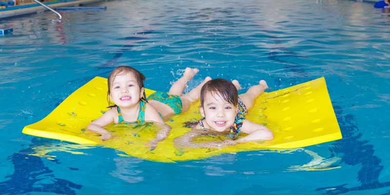 floatation-device, young children on floatation device in pool