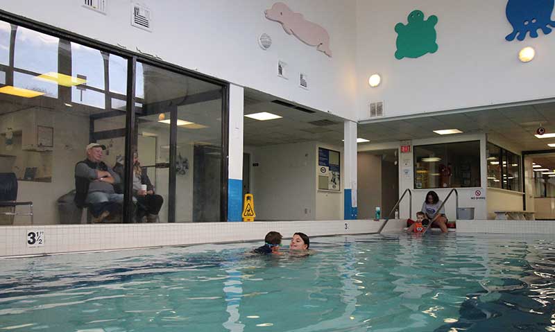 Parents watching their child’s swimming class