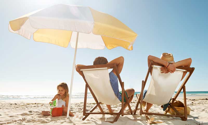 A family watches their child at the beach