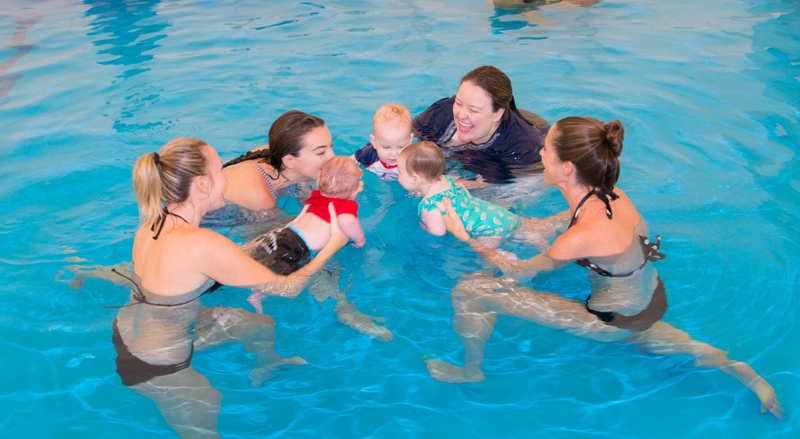 Three babies with their moms and swim teacher enjoying their Water Babies class at Njswim.