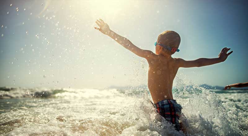 Young boy playing in the water at the beach